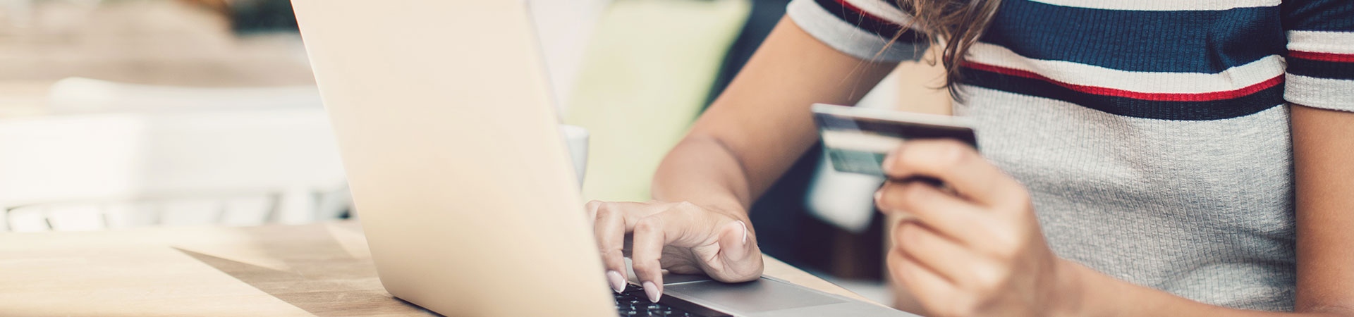 Lady using a credit or debit card on a laptop